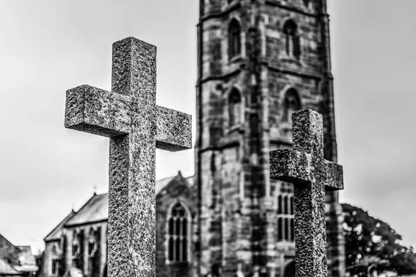 Grav kors med suddiga kyrka i bakgrunden F — Stockfoto