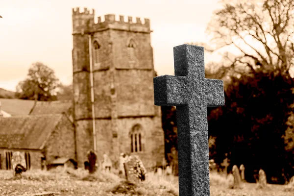 Grabkreuz mit verschwommener Kirche im Hintergrund — Stockfoto