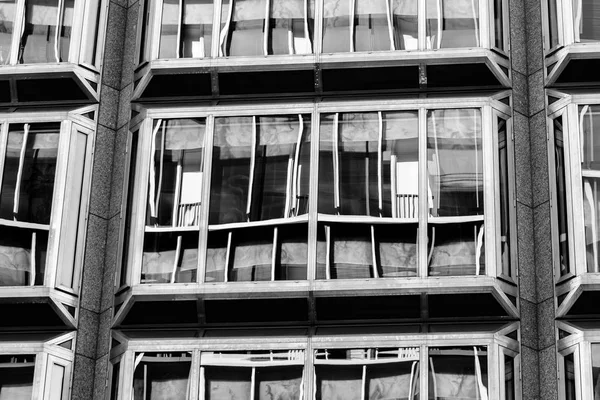 Ventanas en un edificio de varios pisos que muestran reflexiones BW — Foto de Stock