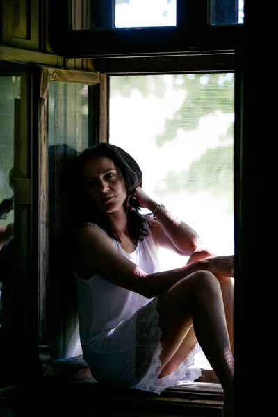Femme triste assis dans sa fenêtre de maison — Photo