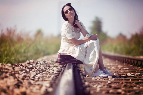 Femme sur voie ferrée avec une valise rétro — Photo