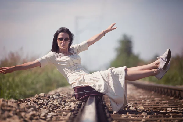 Kobieta siedzi na torach kolejowych — Zdjęcie stockowe