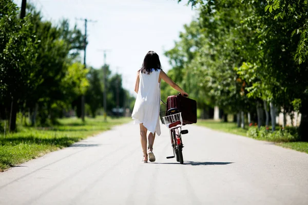 女人推着她那辆旧自行车推的道路上 — 图库照片