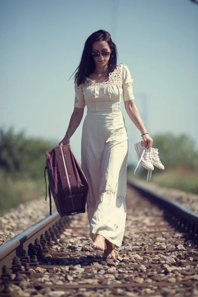 Mujer descalza caminando por las vías del tren — Foto de Stock