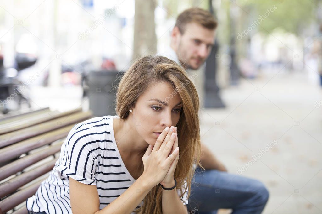 Upset woman and man outdoor on street having relationship problems