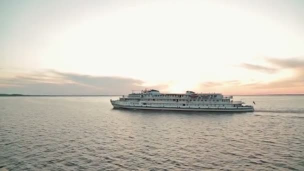 Bateau de croisière naviguant sur la rivière au coucher du soleil 