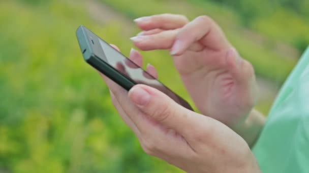 Gros plan de femmes mains utilisant Smartphone dans belle nature 