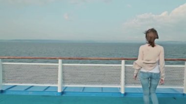 Güverte üzerinde yürüyen genç güzel kadın cruise gemi ve manzaraya zevk.