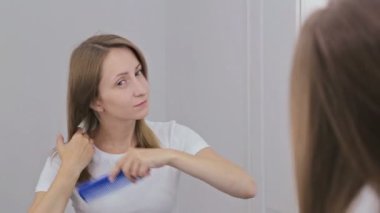 Genç güzel kadın aynanın önünde onun saç tarama