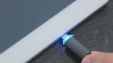 Kadının dijital tablet pc şarj kablosu takmayı Siyah Yıldırım el