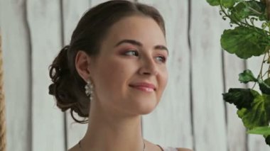 Makyaj ve saç modeli bir salıncak üzerinde güzel kadınla çiçeklerle süslenmiş.