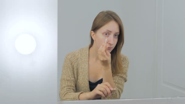 美しい若い女性適用コンシーラー下地クリームを作る — ストック動画