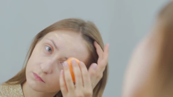 Όμορφη νεαρή γυναίκα ισχύει ΚΑΛΥΠΤΙΚΗ ΚΡΕΜΑ Ίδρυμα μακιγιάζ — Αρχείο Βίντεο