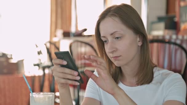 Vrouw met smartphone in cafe — Stockvideo