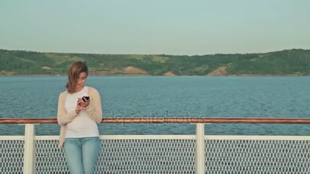 Vrouw met behulp van mobiele telefoon op het dek van het cruiseschip — Stockvideo