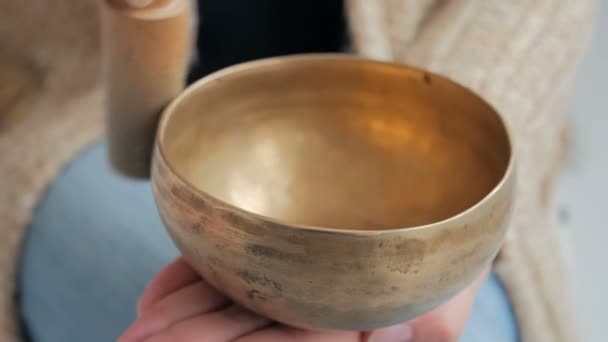 Young woman in cardigan relaxing with nepal singing bowl — Stock Video