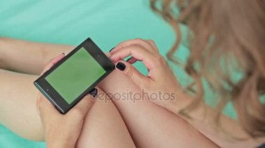 Yeşil ekranlı akıllı telefona bakan kadın