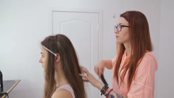 Profesyonel kuaför saç modeli için genç kadın uzun saçlı güzel yapıyor — Stok video