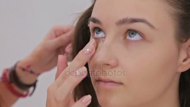 近摄镜头。专业化妆师将奶油基地眼影底漆应用于模型眼 — 图库视频影像