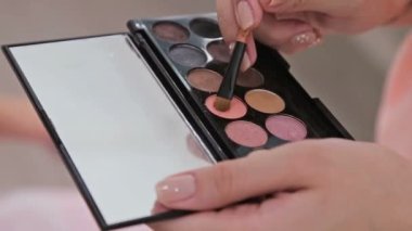 Profesyonel makyöz göz farı kullanıyor.