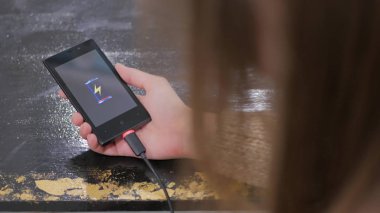 Kadın tutun smartphone ile düşük pil simgesi ekranda