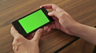 Yeşil perde göstermek ile el akıllı telefon tutan kadın
