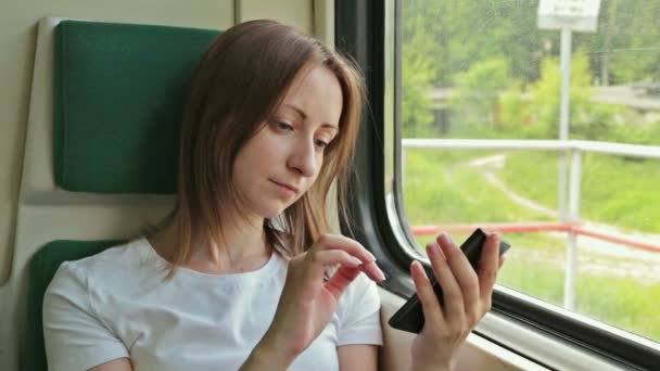 Νεαρή γυναίκα με κινητή συνεδρίαση για το τρένο — Αρχείο Βίντεο