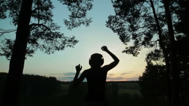 年轻妇女在日落之后在森林里跳舞 — 图库视频影像