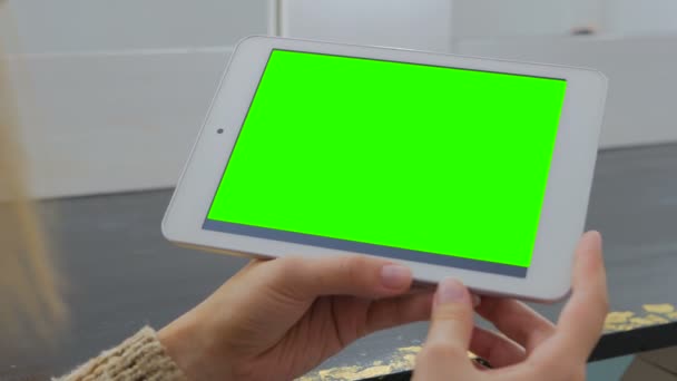 Жінка дивиться на планшетний комп'ютер з зеленим екраном — стокове відео