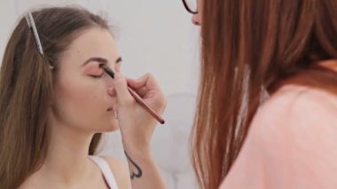 Profesyonel makyöz göz farı kullanıyor.