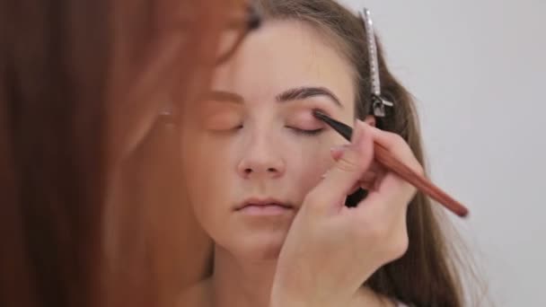 Nära upp skott. Professionell make-up artist ansöker eyeshadow — Stockvideo