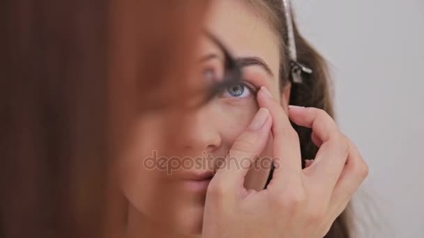 Close-up shot. Visagist crème basis oogschaduw primer toepassen op model oog — Stockvideo