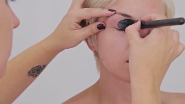 Maquillaje profesional artista aplicando crema base sombra de ojos imprimación para modelar el ojo — Vídeo de stock