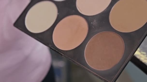 Um tiro de perto. Artista de maquiagem levando blusher da paleta de maquiagem — Vídeo de Stock