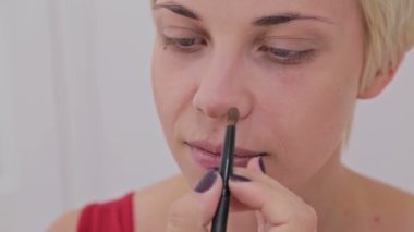 Atış kapatın. Makyöz şehvetli modeli yüzünde makyaj uygulamak