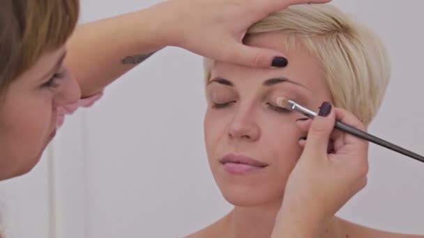 Maquillaje profesional artista aplicando crema base sombra de ojos imprimación para modelar el ojo — Vídeo de stock