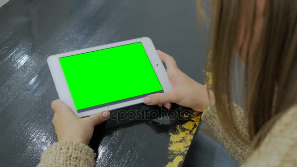 Жінка дивиться на планшетний комп'ютер з зеленим екраном — стокове відео