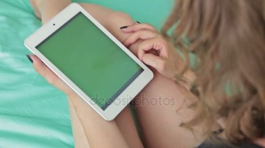 Yeşil ekranlı tablet bilgisayara bakan kadın