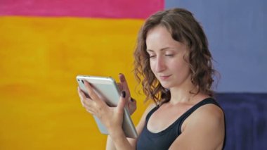 Kıvırcık kadın Tablet PC'yi kullanma