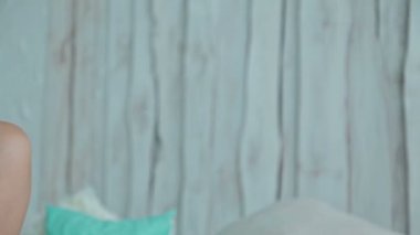 Genç kıvırcık kadın yatakta tablet pc ile oturuyordu. Dolly vurdu