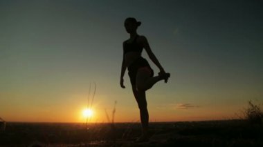 Gün batımında - dans poz efendisi pratik Yoga parkta kadın