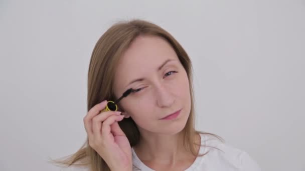 Mooie jonge vrouw zetten mascara — Stockvideo
