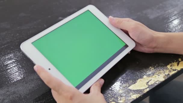 Vrouw op zoek naar tablet computer met groen scherm — Stockvideo