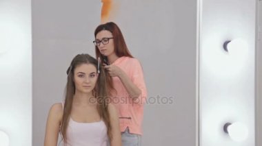 Profesyonel kuaför saç modeli için genç kadın güzel yapıyor