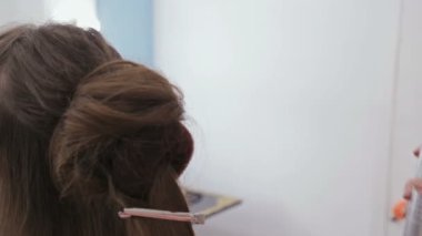 Atış kapatın. Profesyonel kuaför saç modeli için genç kadın güzel yapıyor
