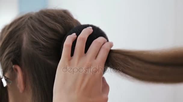 Два выстрела. Профессиональный парикмахер делает прическу для молодой красивой женщины с длинными волосами — стоковое видео