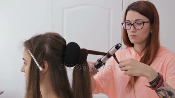 Dos disparos. Peluquería profesional haciendo peinado para mujer bonita joven — Vídeos de Stock