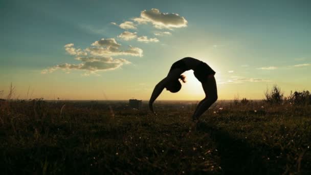 Mujer practicando yoga en el parque al atardecer: retrocede, posa en la rueda — Vídeos de Stock