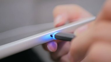 Kadının tablet şarj kablosu takmayı Siyah Yıldırım el
