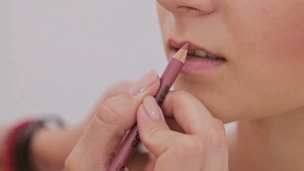 Primer plano. Maquillador profesional aplicando contorno de labios — Vídeo de stock